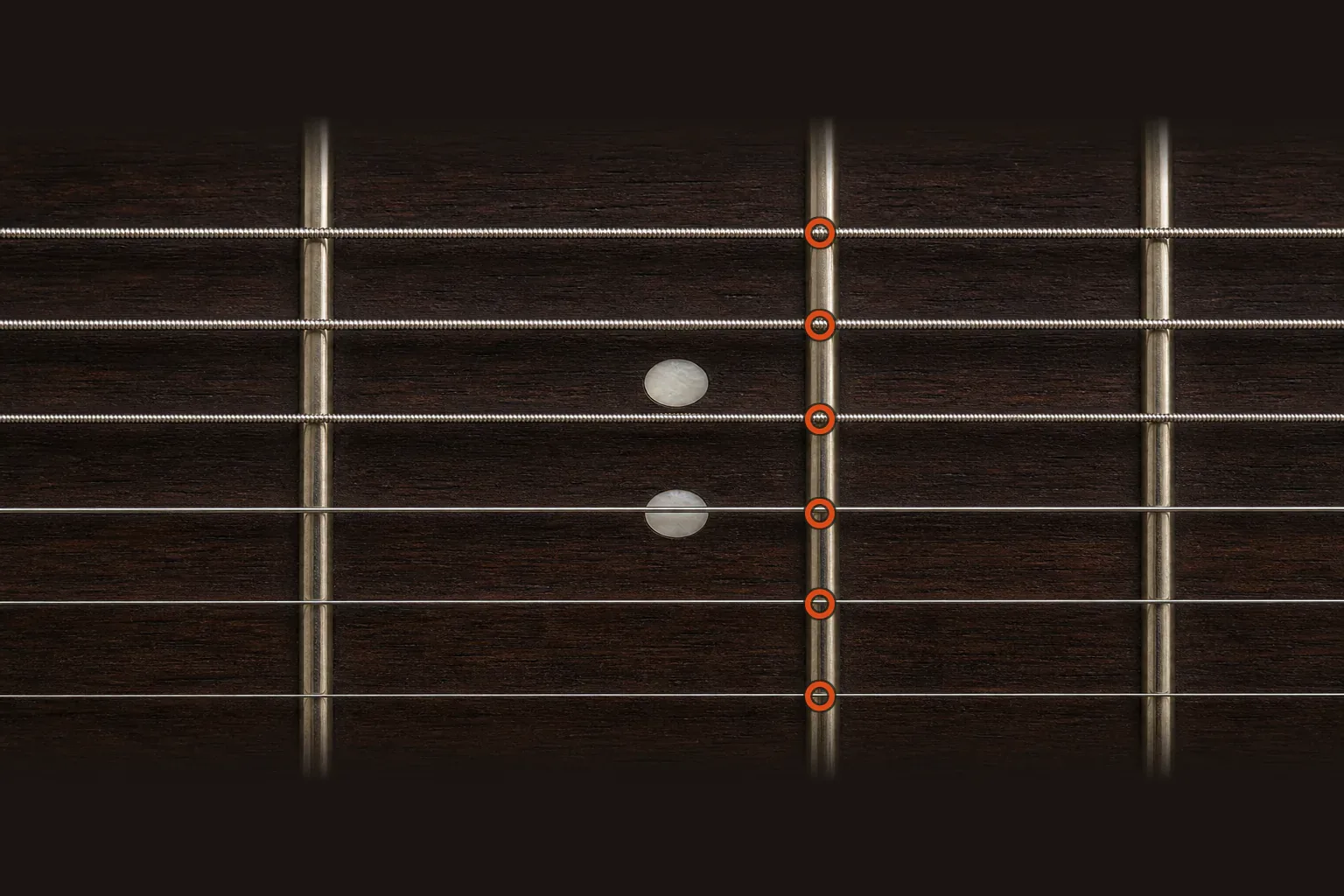 Six guitar strings crossing a double-dot fretboard landmark with orange markers aligned over the harmonic node