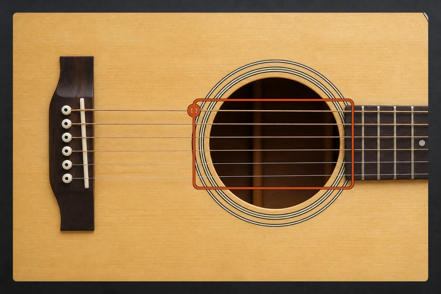 Six acoustic guitar strings crossing a soundhole with an orange circle on the upper bass string and an orange strumming window